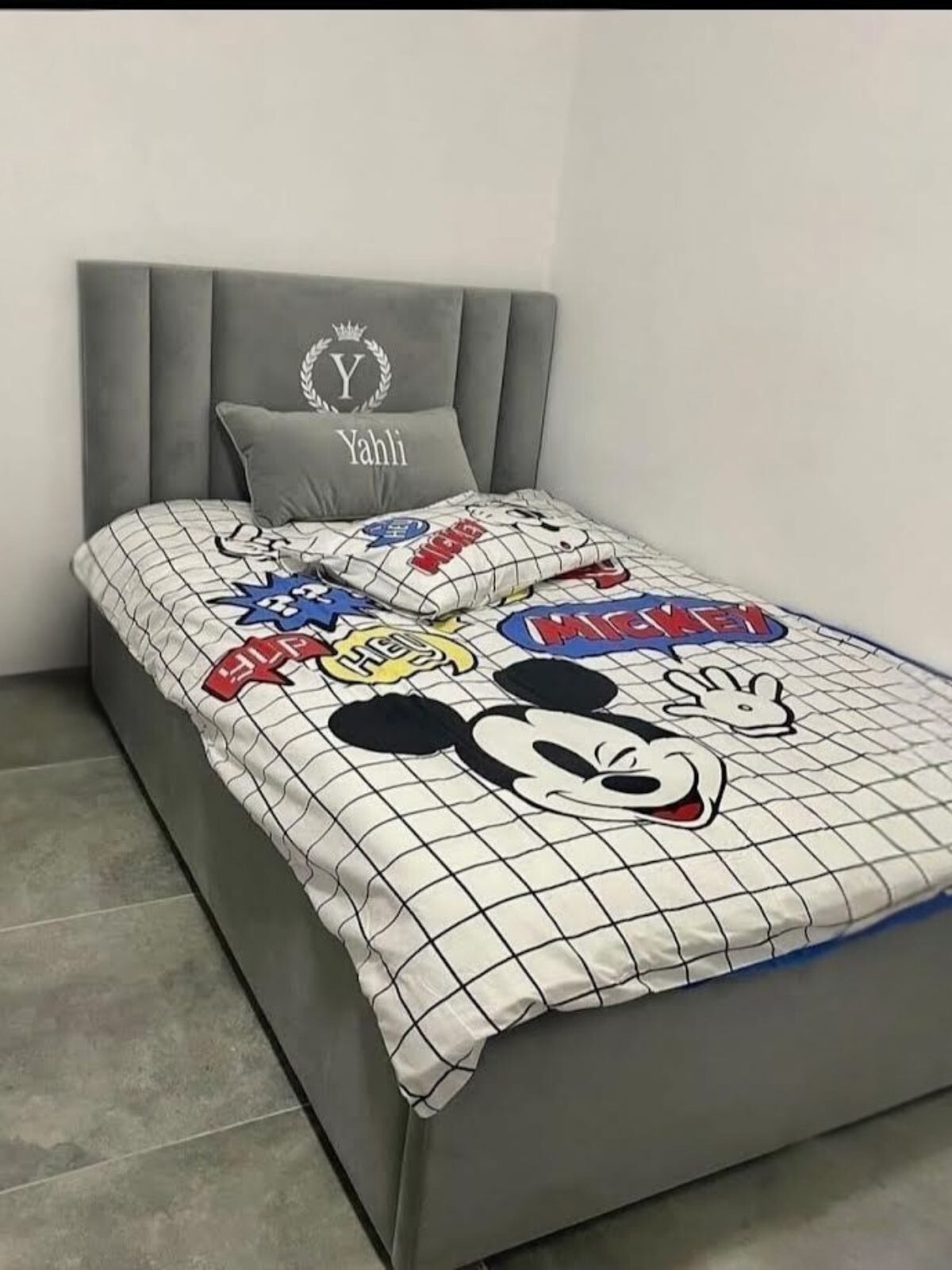 מיטת נוער מרופדת באפור עם ראש מיטה בקווים אנכיים עם שילוב חריטה אישית