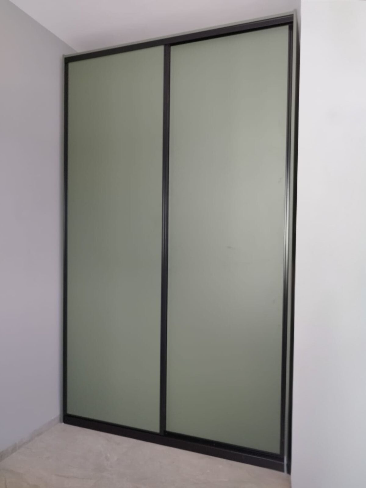 ארון הזזה בעיצוב מודרני ונקי, עם חזית בגוון ירוק־מעושן