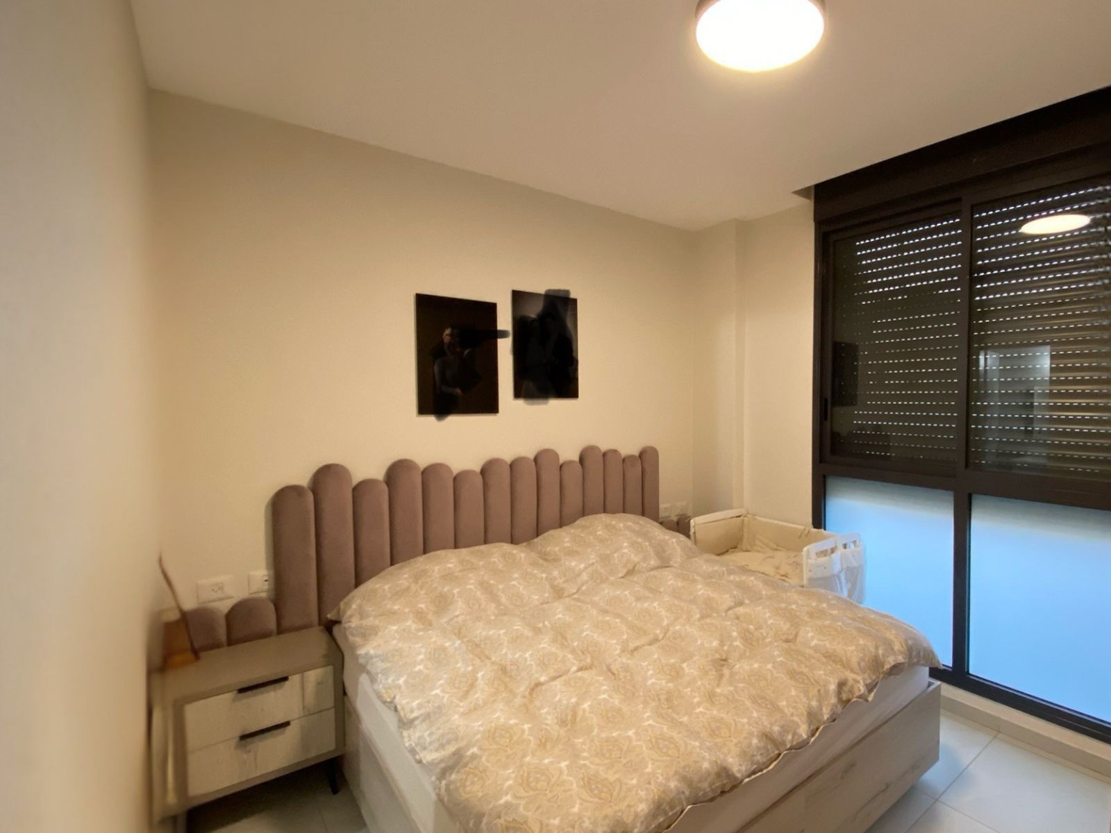 מיטה מרופדת בעיצוב ייחודי, עם ראש מיטה אחיד ודקורטיבי בקווים מעוגלים ומדורגים למראה אלגנטי, נעים ועכשווי.