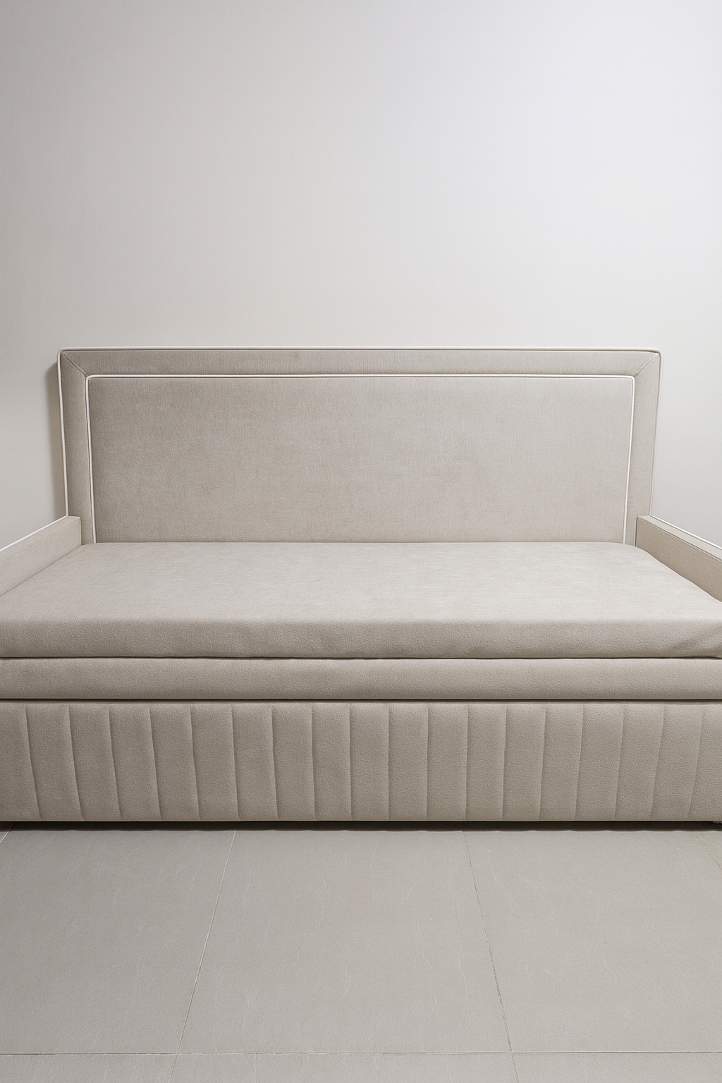 מיטת נוער מרופדת בהירה עם ראש מיטה ישר ובסיס מרופד בתיפורים אנכיים, בשילוב מסגרת בהירה מובלטת