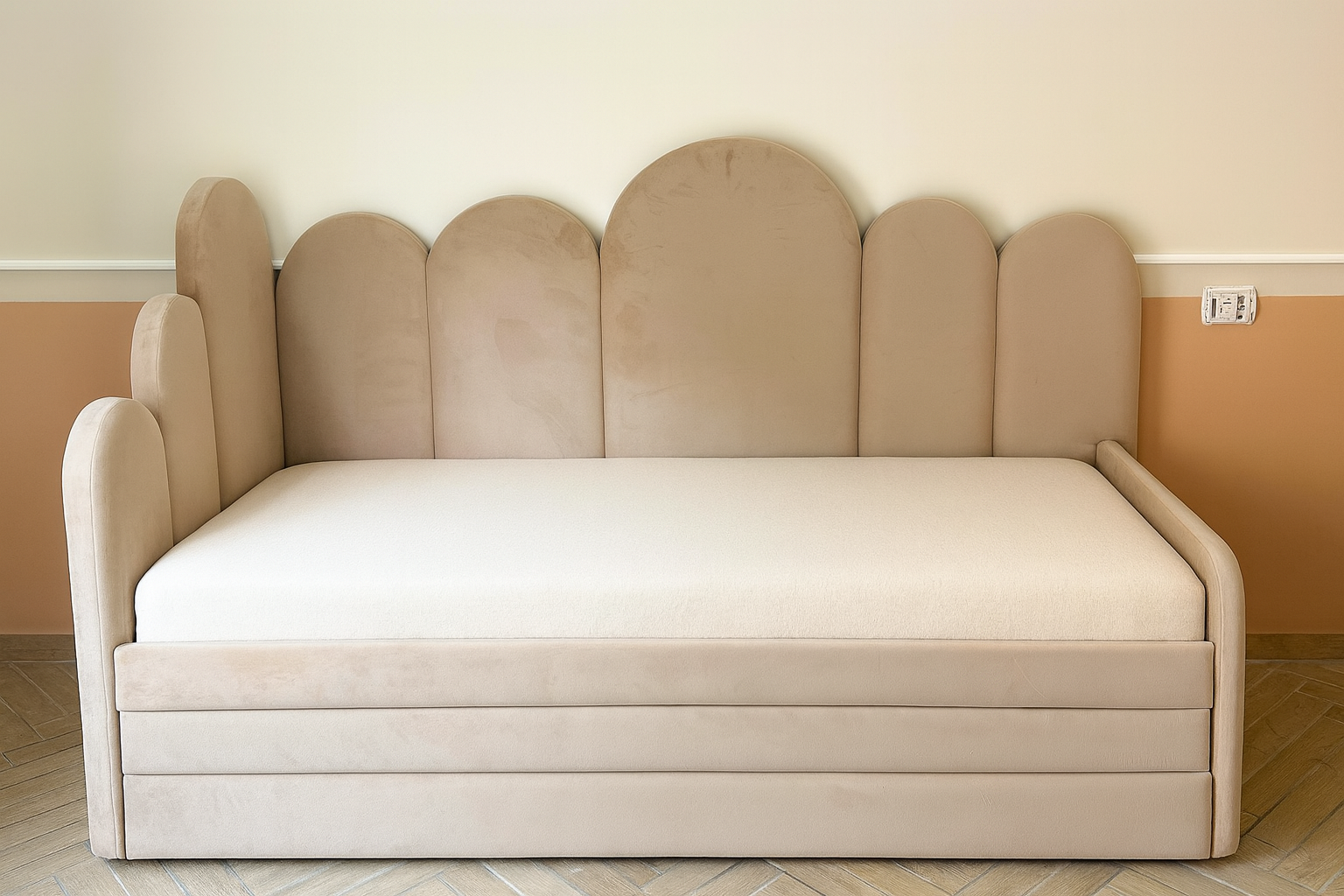 מיטת נוער מרופדת בגוון בהיר, עם ראש מיטה בעיצוב קמור ובסיס מרופד בקווים נקיים.