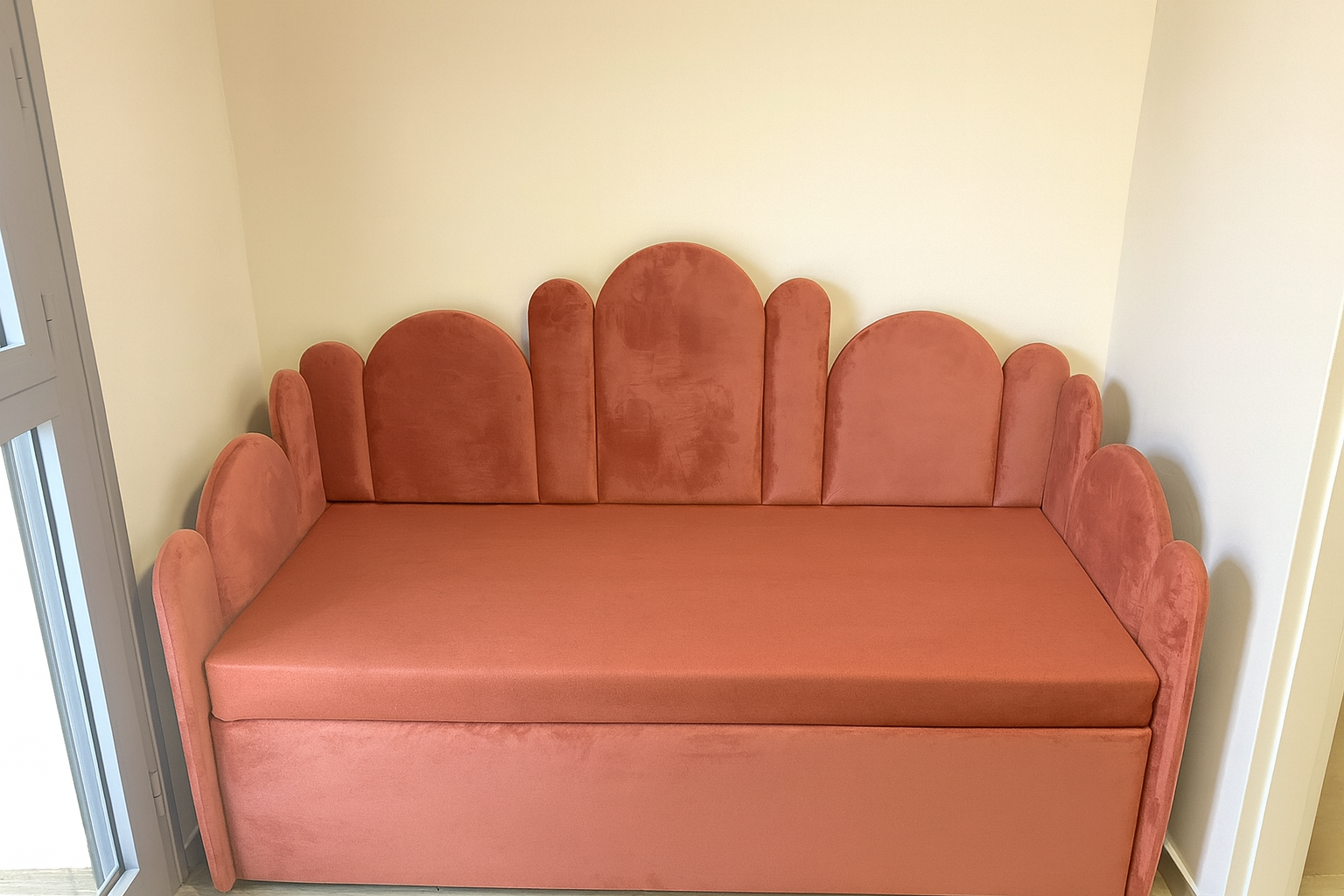 מיטת נוער מרופדת מודרנית בבד קטיפתי עם ראש מיטה מעוגל בעיצוב ייחודי בגוון וורוד אפרסקי