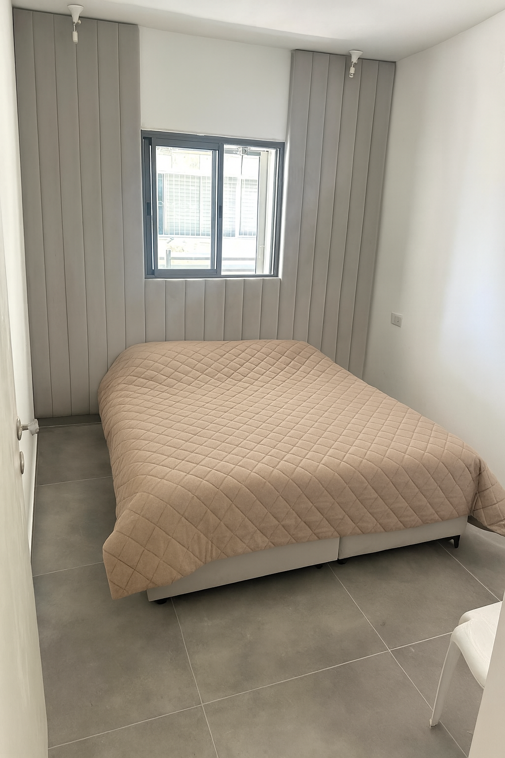 מיטת חדר שינה עם ראש מיטה מרופד בהתאמה אישית לאורך הקיר בעיצוב אנכי לחדר שינה