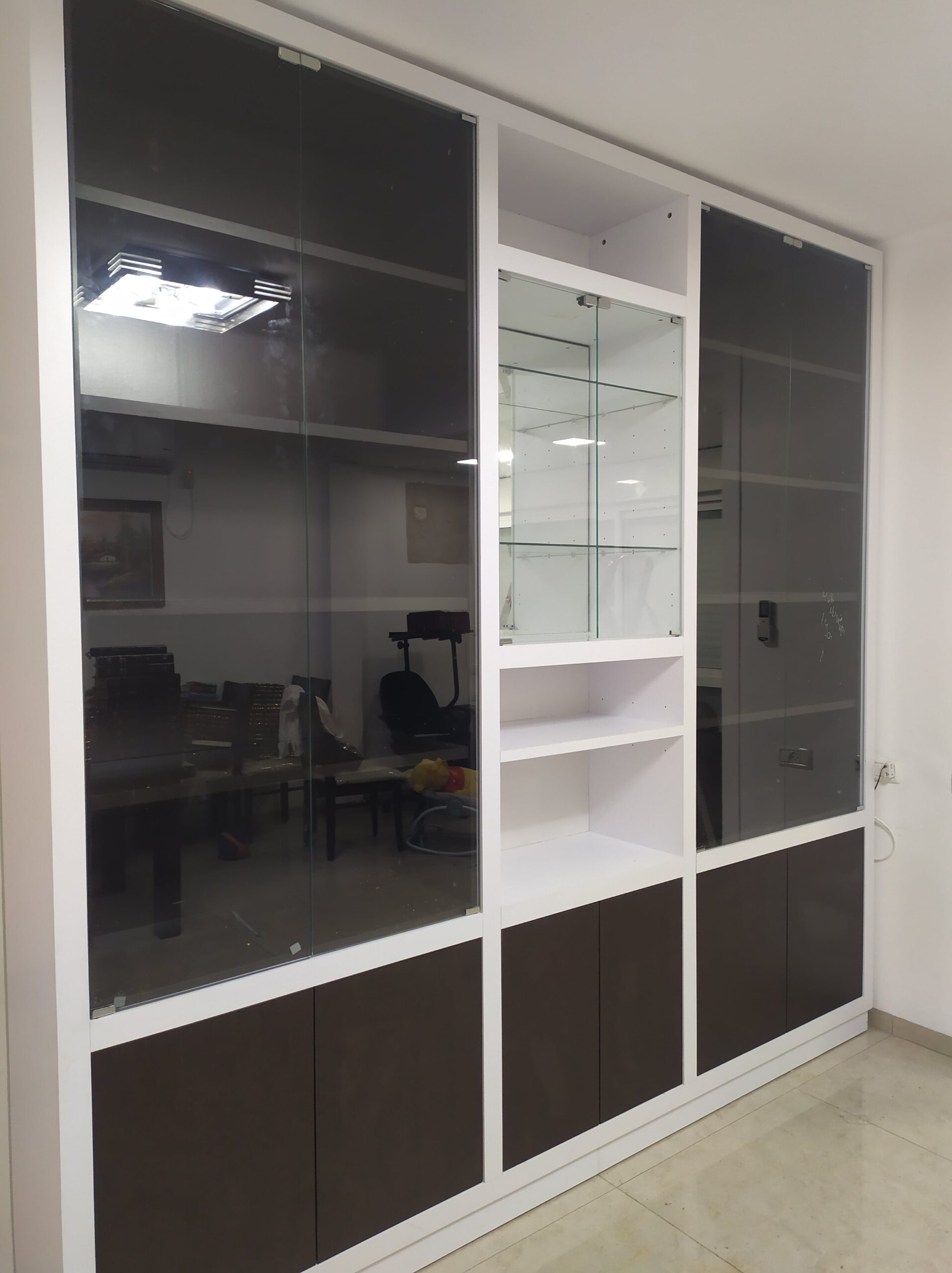 ספריית קודש בעלת דלתות זכוכית כהה, מסגרת בהירה וויטרינה מרכזית