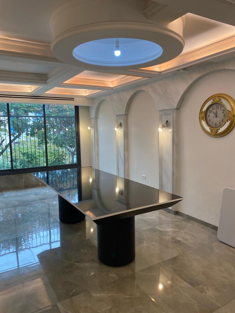 שולחן אוכל מודרני עם משטח כהה מבריק ורגליים גליליות מסיביות.