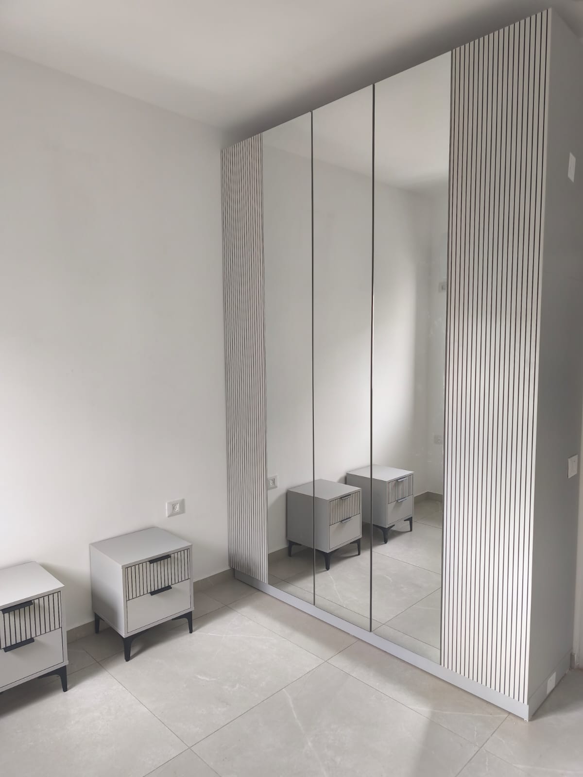 ארון פתיחה משולב פאנלים מחורצים בקווים אנכיים עם דלתות מראה עם שידות תואמות