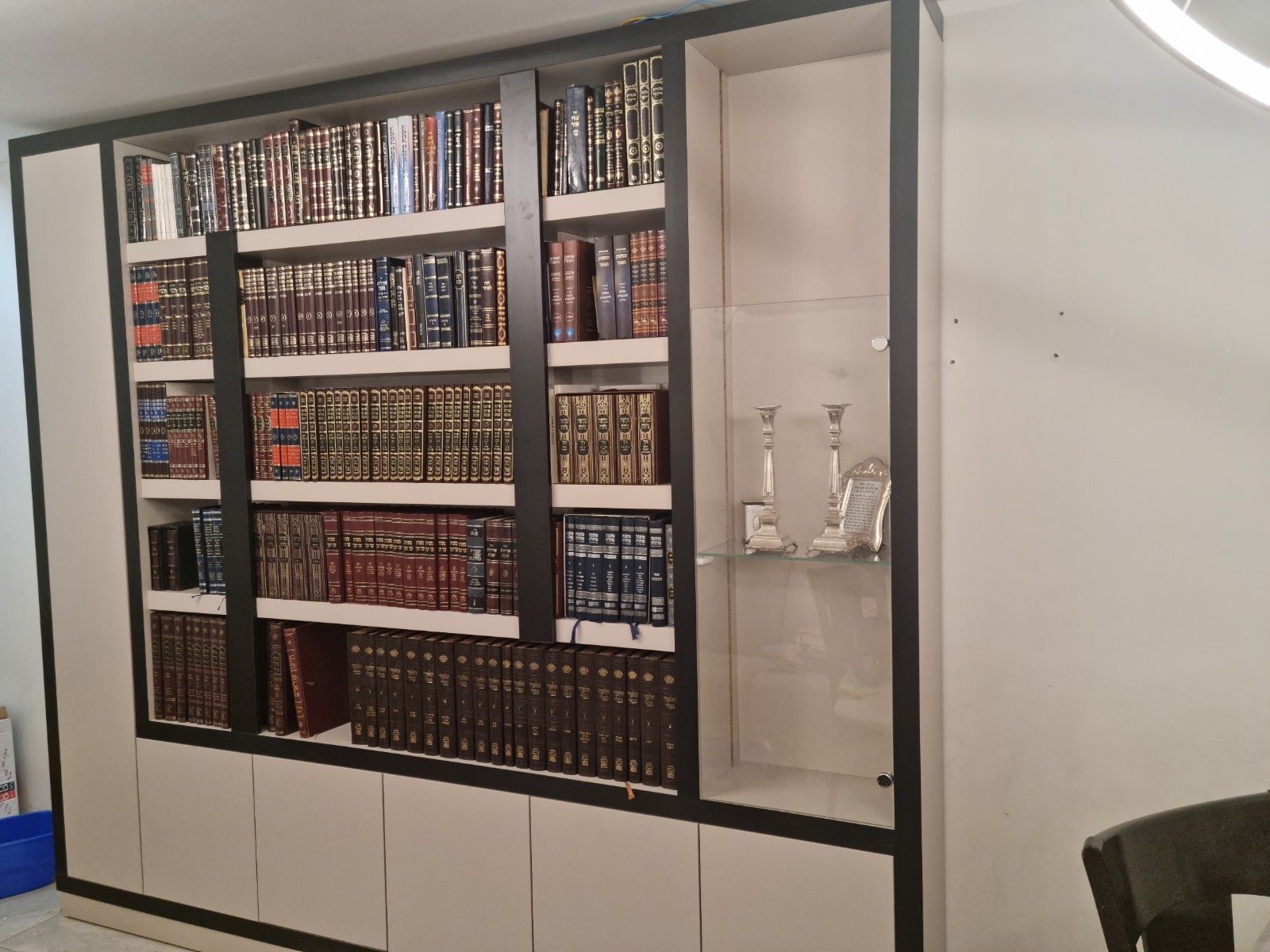 ספריית קודש עם מדפי ספרים עמוקים, מסגרת כהה וויטרינה צדדית עם דלת זכוכית,בשילוב פסי עץ דקורטיביים