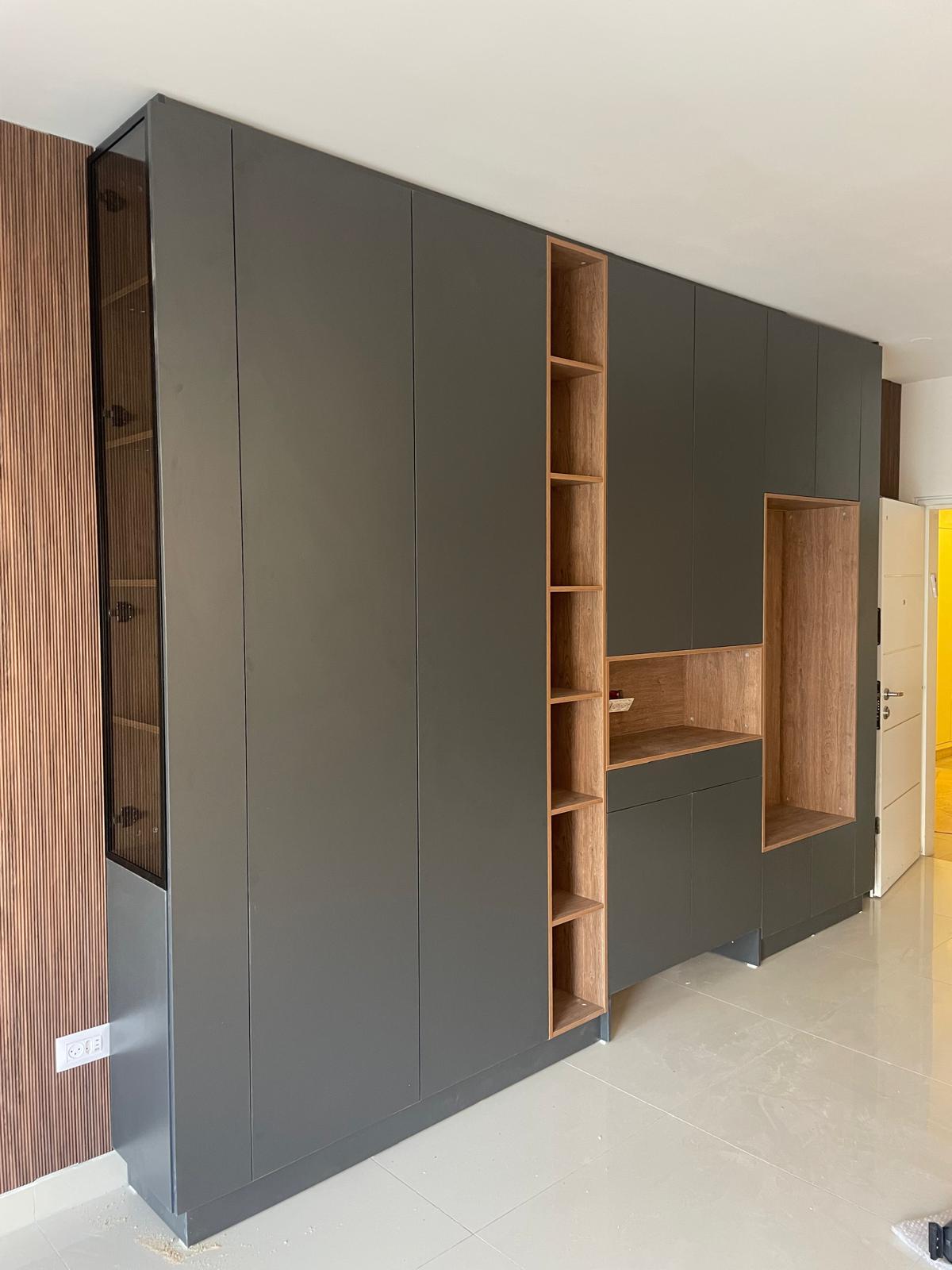 ארון פתיחה עם חזית כהה מרשימה, בשילוב נישות ועמדת עבודה מעץ טבעי, למראה יוקרתי, חכם ומלא אופי.