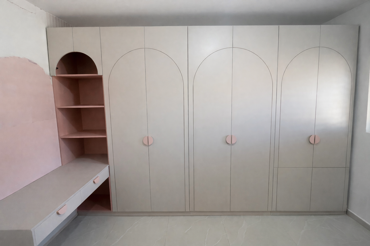 ארון חדר ילדיםבצבע סהרה עם חריטה מעוצבת עם שילוב שולחן כתיבה יוצא עם מדפים פתוחים בגוון ורוד ניוד עם נישה עליונה מקושתת