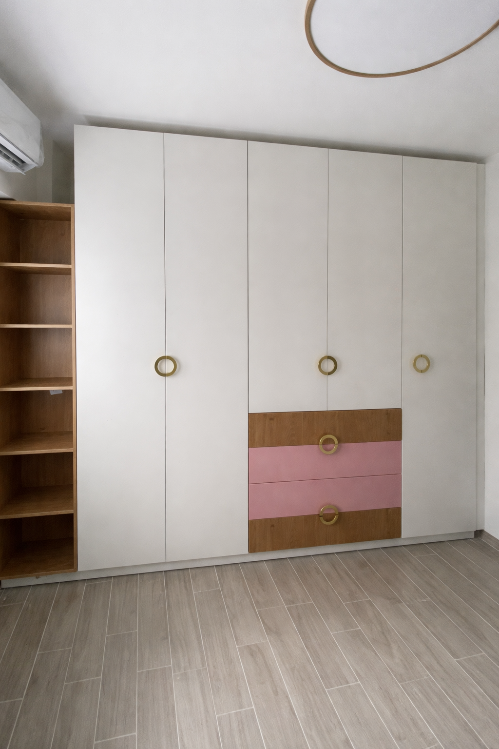 ארון בגדים מעוצב לחדר ילדים בשילוב שמנת, עץ ונגיעות ורוד עם ידיות זהב עגולות