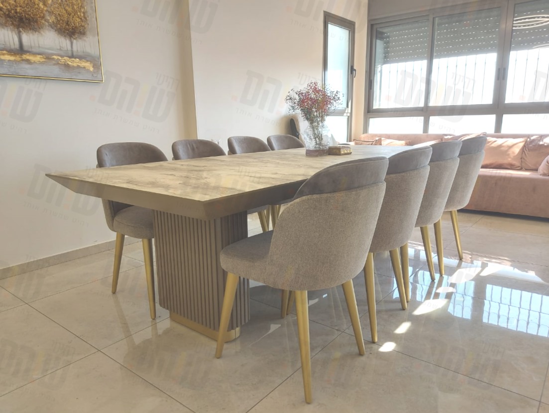 שולחן פינת אוכל מעוצב עם רגליים מחורצות וכיסאות מרופדים בגוון אפור עם רגלי זהב